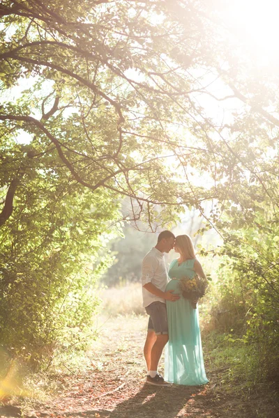 Heureux et jeune couple enceinte marche et enchanter la nature — Photo