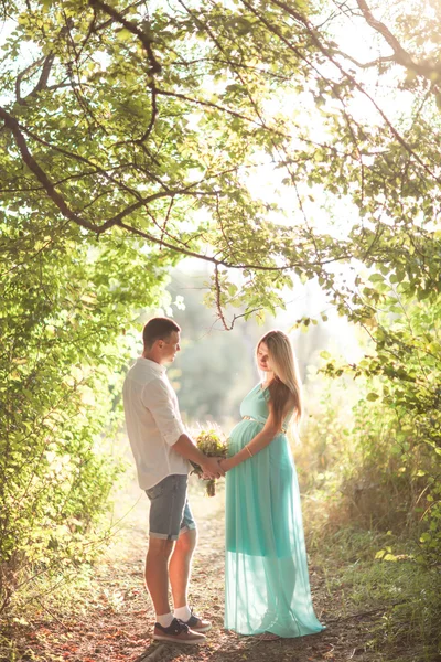 Feliz e jovem casal grávida andando e desfrutando da natureza — Fotografia de Stock