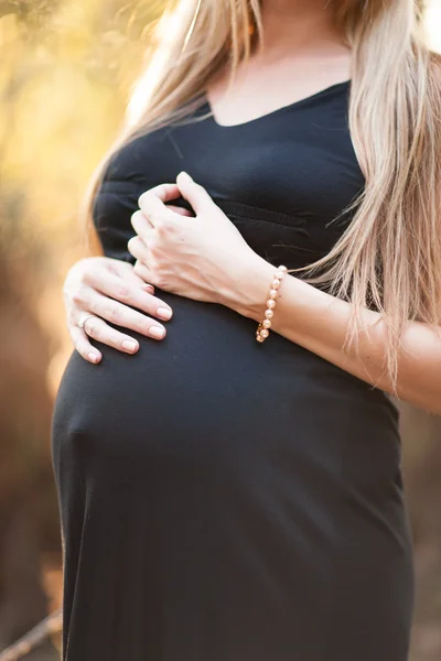 Close up of human hands holding pregnant belly — Stock Photo, Image