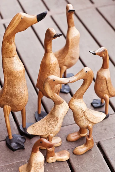 Seven hand made wooden ducks on wood background — Stock Photo, Image