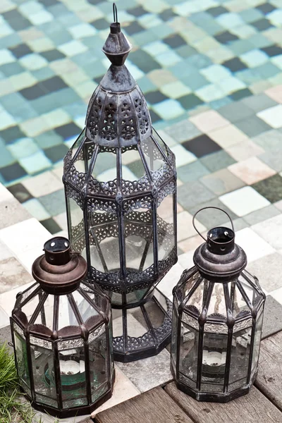 Vintage candle lamps standing near swimming pool. Summer in wint