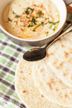 bir kase zeytinyağı ve pide cips ile kremsi humus.