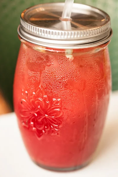 Pink raspberry smoothie in a mason jar with straws on a rustic w — Stock Photo, Image