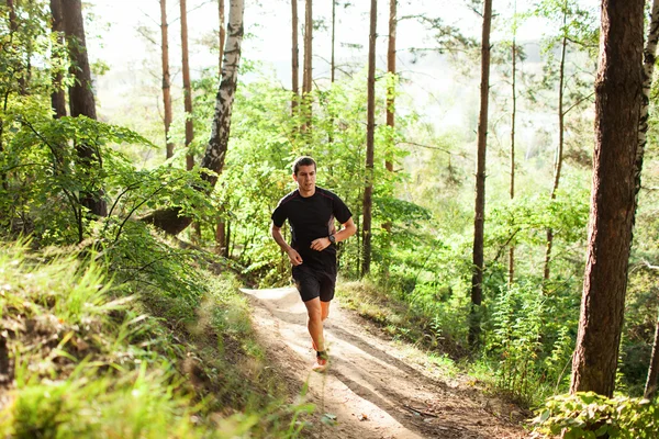 Orman yolu üzerinde çalışan erkek atlet runner — Stok fotoğraf