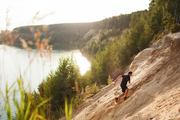 Un athlète coureur sur la route en forêt — Photo