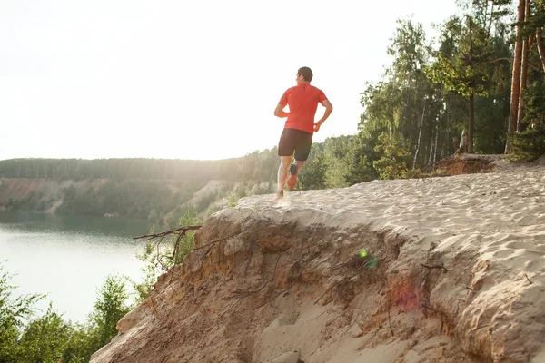 Male athlete runner running on road in forest — Stock Photo, Image