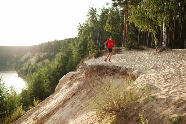 Un athlète coureur sur la route en forêt — Photo