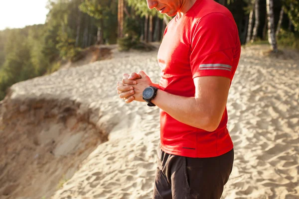 Corredor en el sendero de montaña mirando reloj deportivo inteligente, chec — Foto de Stock