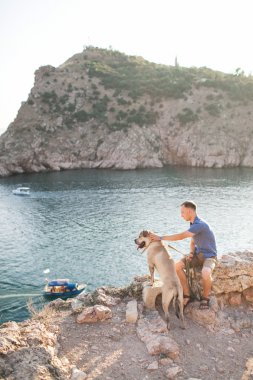 Genç beyaz erkek köpekle gündoğumu sırasında yürüyüş