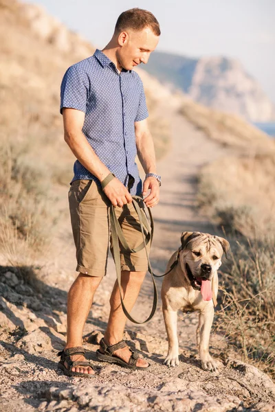 年轻的白种人男性在日出期间带着狗散步 — 图库照片