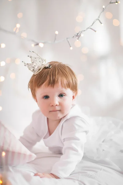 Linda niña jugando en una cama entre cálida Navidad suave l —  Fotos de Stock