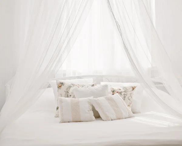 Letto bianco accogliente con cuscino vintage — Foto Stock