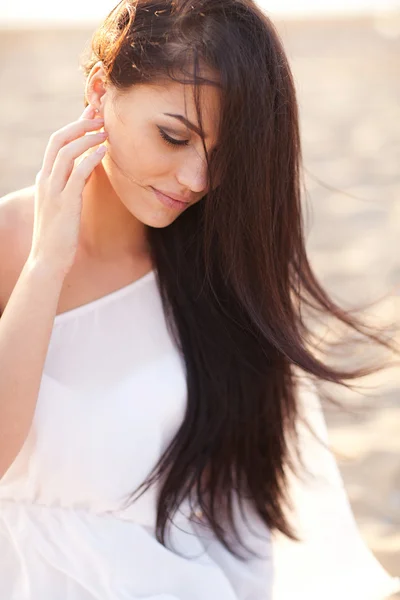 Beautiful tender woman posing on the sunset beach — Stock Photo, Image