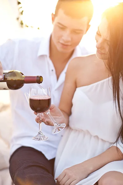 Casal de ternura com vinho na praia do pôr do sol — Fotografia de Stock