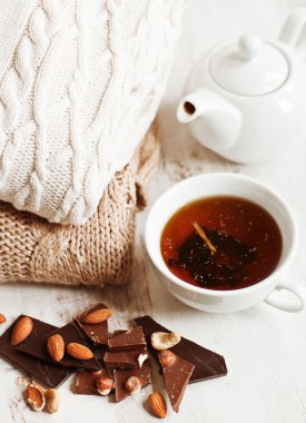 bir fincan sıcak içecek, örgü elbiseler, tarçın ve çiçekler. Kış ruh hali