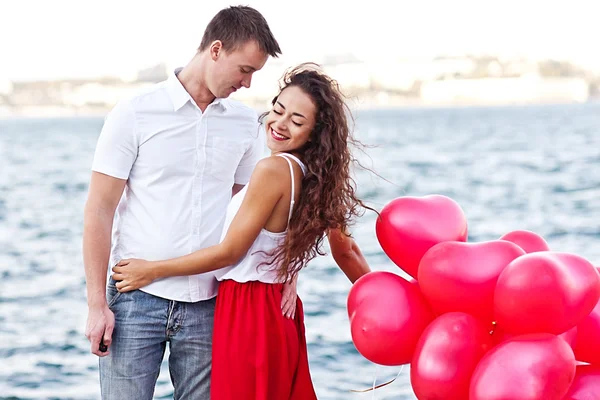 Kırmızı baloons-hearts tutan genç bir çift. Sevgililer günü — Stok fotoğraf