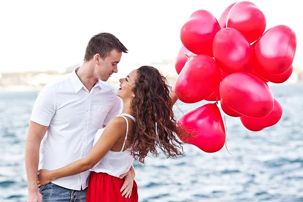 Kırmızı baloons-hearts tutan genç bir çift. Sevgililer günü — Stok fotoğraf