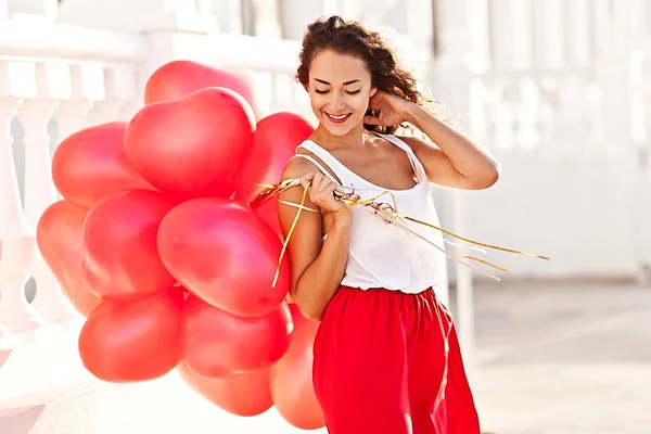 Unga vackra kvinnan anläggning röda baloons-hjärtan. Alla hjärtans dag — Stockfoto