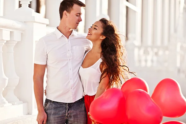 Casal adolescente segurando balões vermelhos corações. Dia dos namorados — Fotografia de Stock