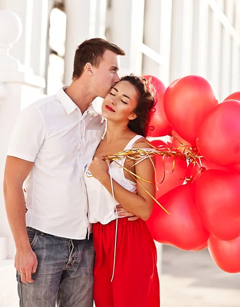 Pareja adolescente sosteniendo corazones de globos rojos. día de San Valentín Imagen de stock