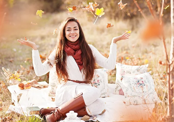 Ritratto di donna felice che gioca con le foglie autunnali nella foresta — Foto Stock