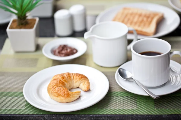 ホテルの朝食。クロワッサンとコーヒーをミルク付き — ストック写真