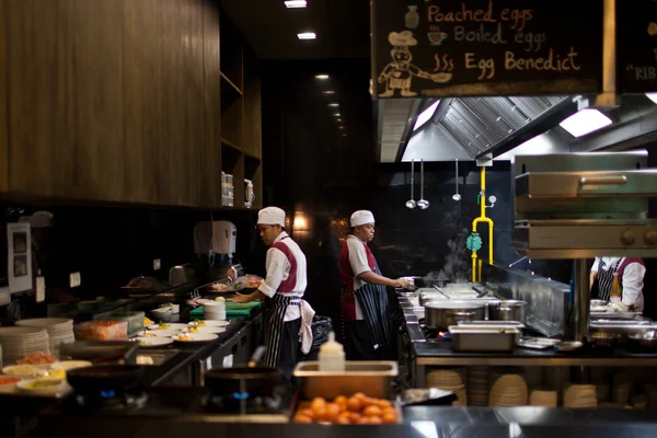 Overvolle keuken, een smalle gangpad, werken chef-kok. — Stockfoto