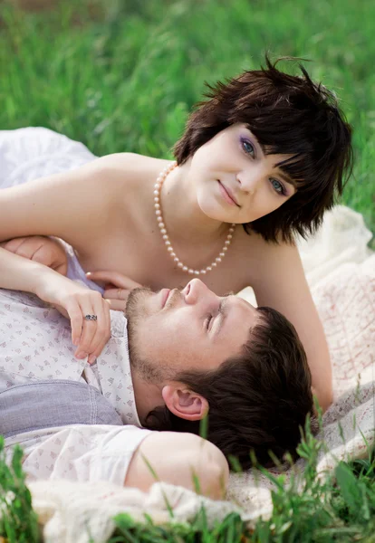 Young tenderness couple relax in blossoming garden — Stock Photo, Image