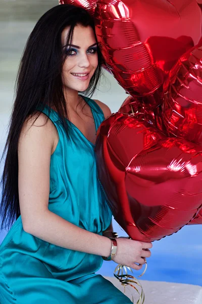 Schöne brünette junge Frau mit einem herzförmigen Luftballons. Valentinstag. — Stockfoto