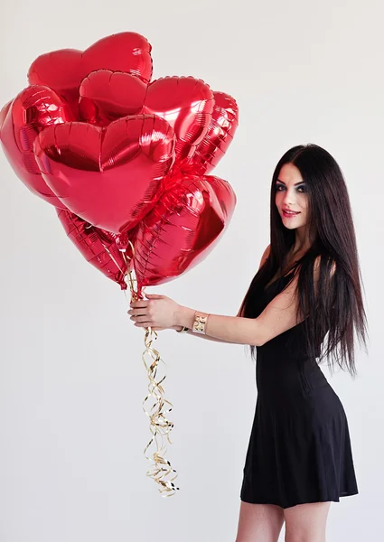 Piękna brunetka młoda kobieta z balony w kształcie serca. Walentynki. — Zdjęcie stockowe