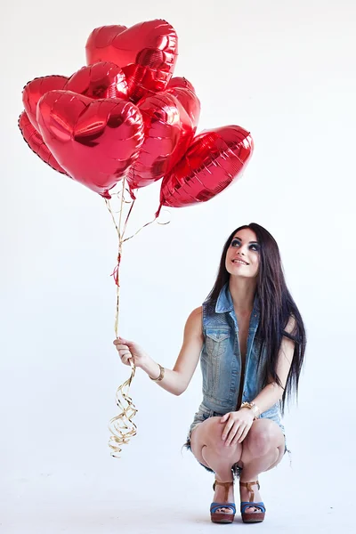 Beautiful brunette young woman with a heart-shaped balloons. Valentine's day. Royalty Free Stock Photos