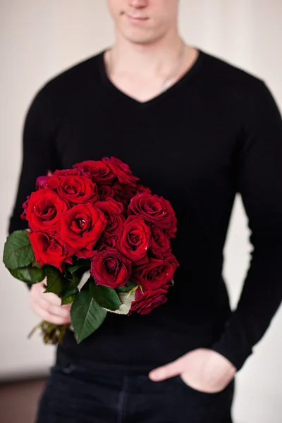 Happy romantic husband holding rose flower prepared to celebrate — Stock Photo, Image