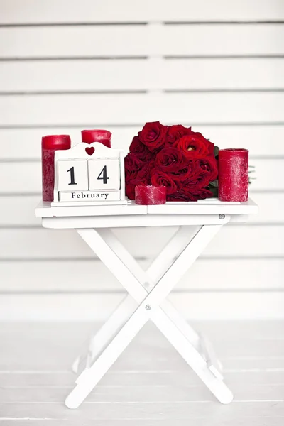 Red roses lay on the table near calendar  with the date of Febru — Stock Photo, Image