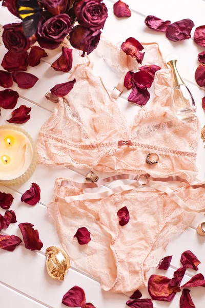 Tenderness peachys lingerie with roses petails, candle and accessories. Love mood. — Stock Photo, Image