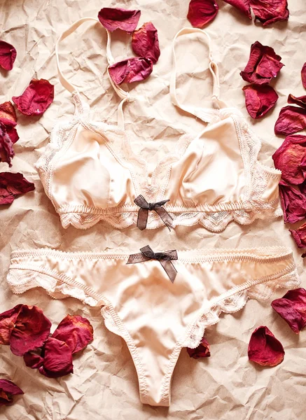 Tenderness peachys lingerie with candle and dry petals. Love moo — Stock Photo, Image