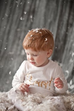 tüy ile yeni doğan bir bebek. tüyler kazık ve ca oturan çocuk