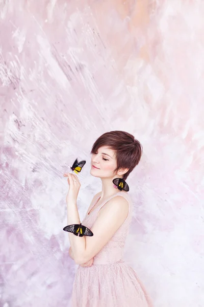 Ung vacker kvinna med exotiska svarta och gula fjärilar — Stockfoto