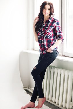 Genç çekici kadın stüdyoda poz kareleri alınmış gömlekli. Casual stile.