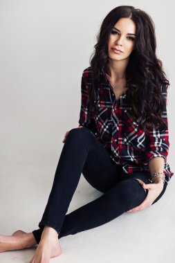 Genç çekici kadın stüdyoda poz kareleri alınmış gömlekli. Casual stile.