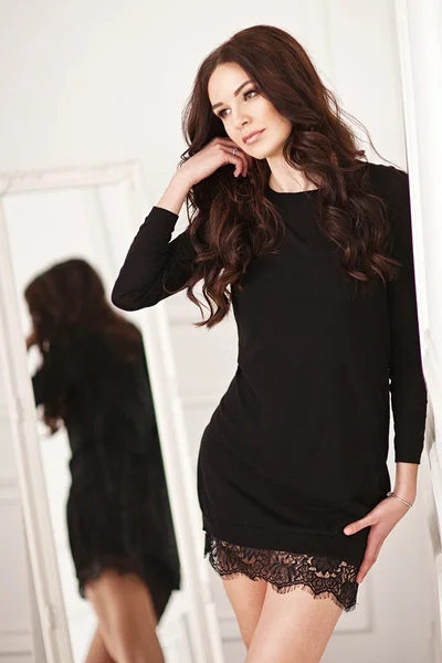 Jonge brunette dame in zwarte kanten jurk poseren in witte kamer. tederheid — Stockfoto