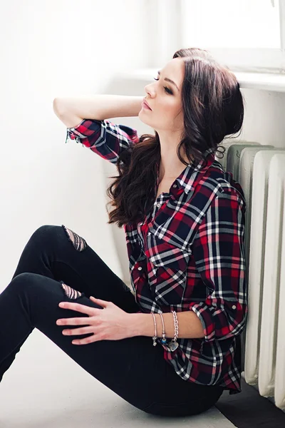 Young attractive woman in squared shirt posing in studio. Casual stile. — Stock Photo, Image