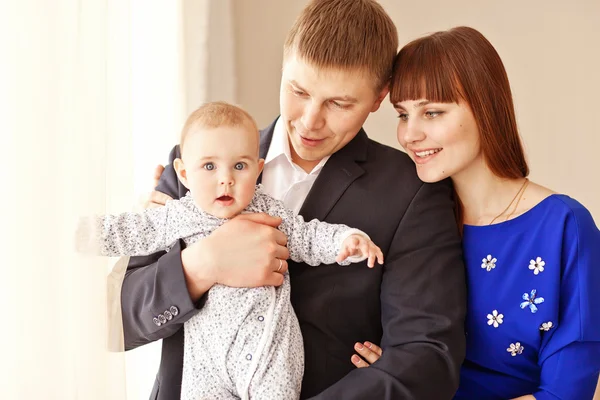 Retrato de una joven familia feliz con el niño en casa — Foto de Stock