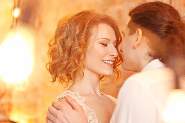 Young man and woman together over brick red wall and lights — Stock Photo, Image