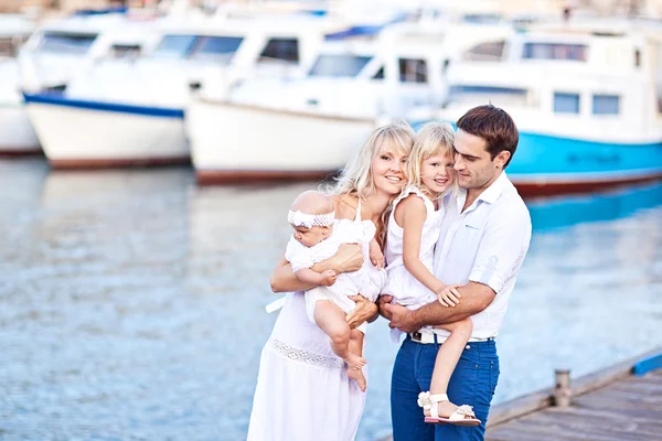 Lyckliga familjen ha roligt gå på förtöjningen nära yachts — Stockfoto