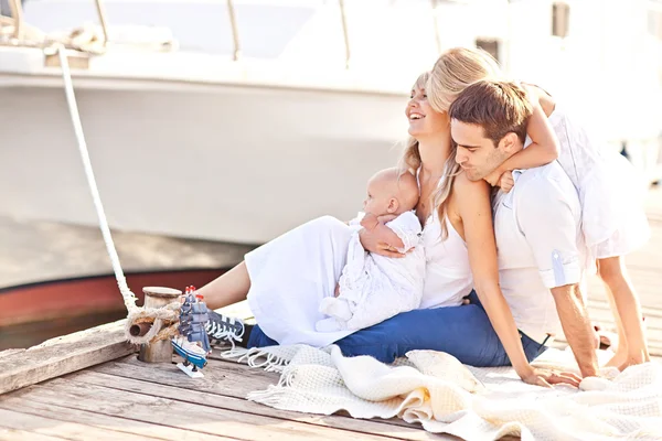 Lyckliga familjen ha roligt gå på förtöjningen nära yachts — Stockfoto