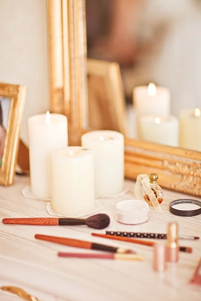 Spiegel, kaarsen, poeder, bladerdeeg, eyeliner en andere cosmetica op tafel — Stockfoto