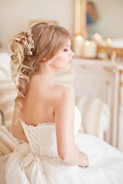 Joven novia atractiva en marfil ternura vestido de novia posando en vinatge interior —  Fotos de Stock