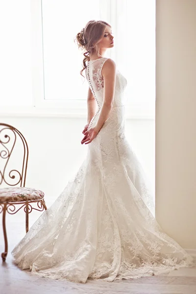 Young attractive bride in ivory tenderness wedding dress posing in vinatge interior — Stock Photo, Image