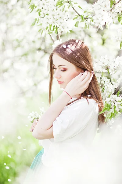 Portrait of young lovely woman in spring flowers — Stock Photo, Image