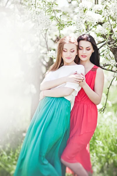 Portrait of young lovely two womans in spring flowers — Stock Photo, Image